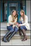 Freundinnen mit Smartphone, Jeggings und Stiefel